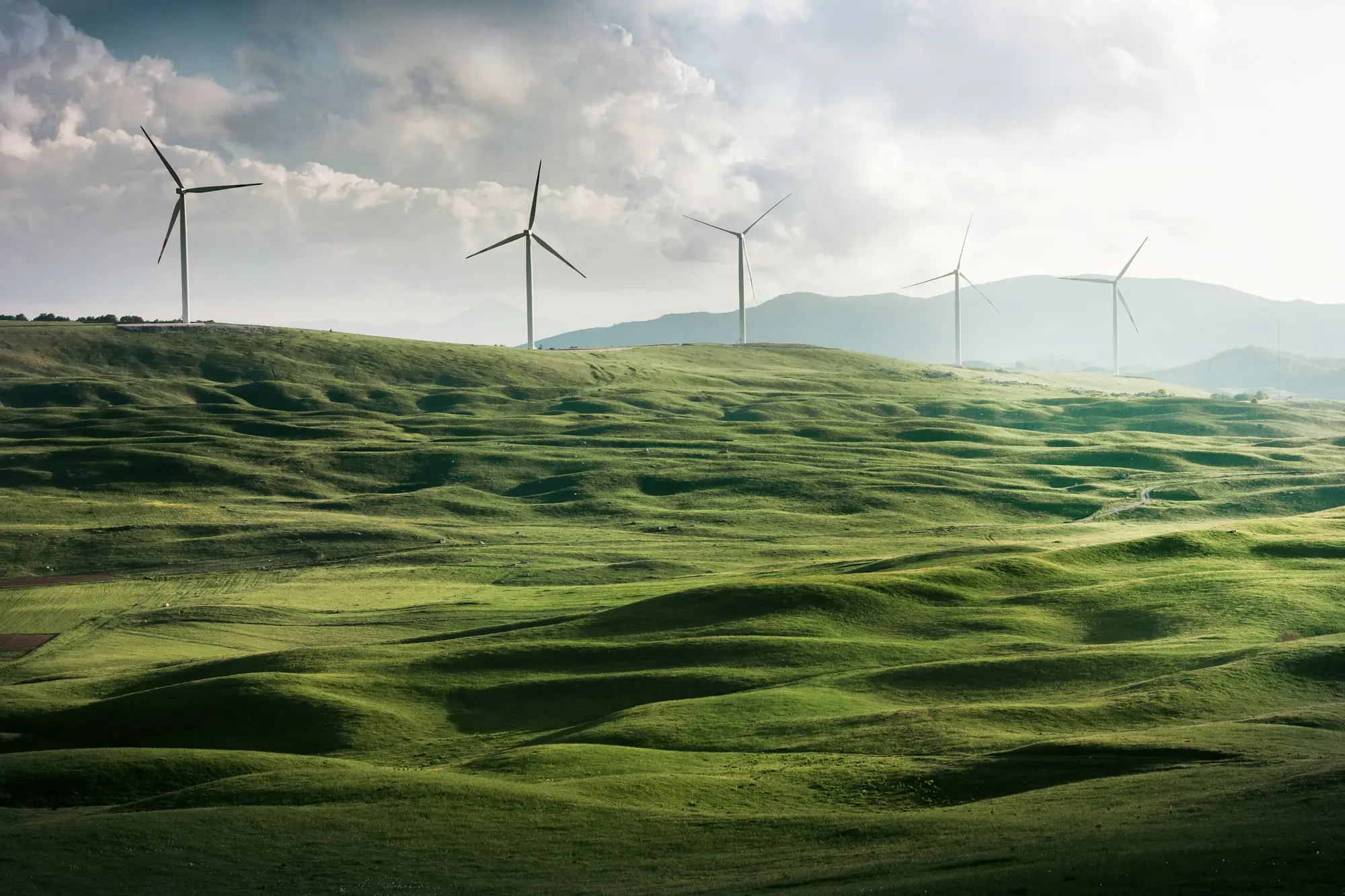 Windkraftanlagen in einer grünen Hügellandschaft